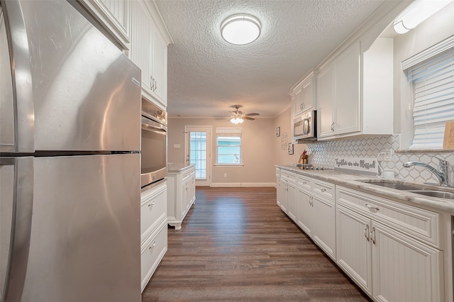 kitchen featuring decorative backsplash, stainless steel appliances, sink, white cabinetry, and dark hardwood / wood-style flooring