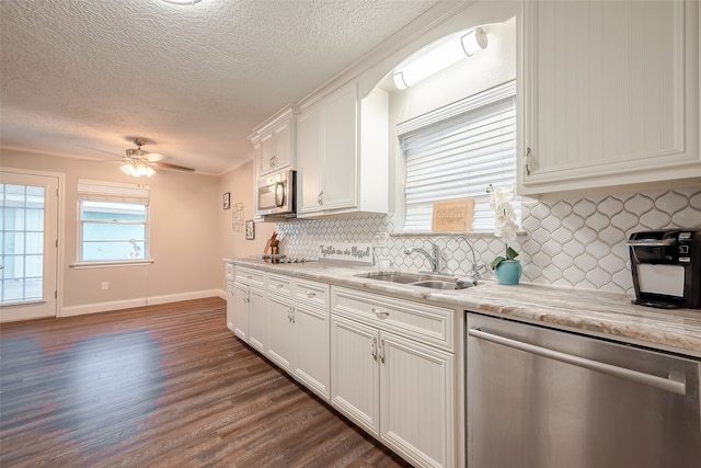 kitchen featuring appliances with stainless steel finishes, white cabinetry, sink, and dark hardwood / wood-style flooring