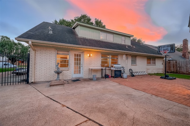 back house at dusk featuring a patio area