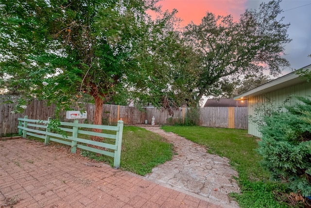 yard at dusk featuring a patio area