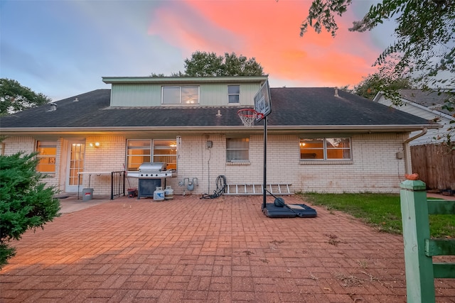 back house at dusk featuring a patio area