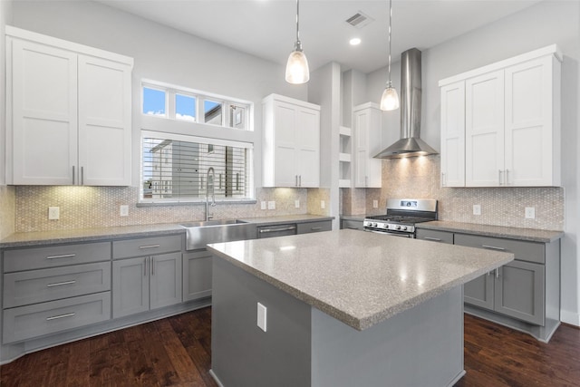 kitchen featuring wall chimney range hood, stainless steel appliances, a sink, and gray cabinetry