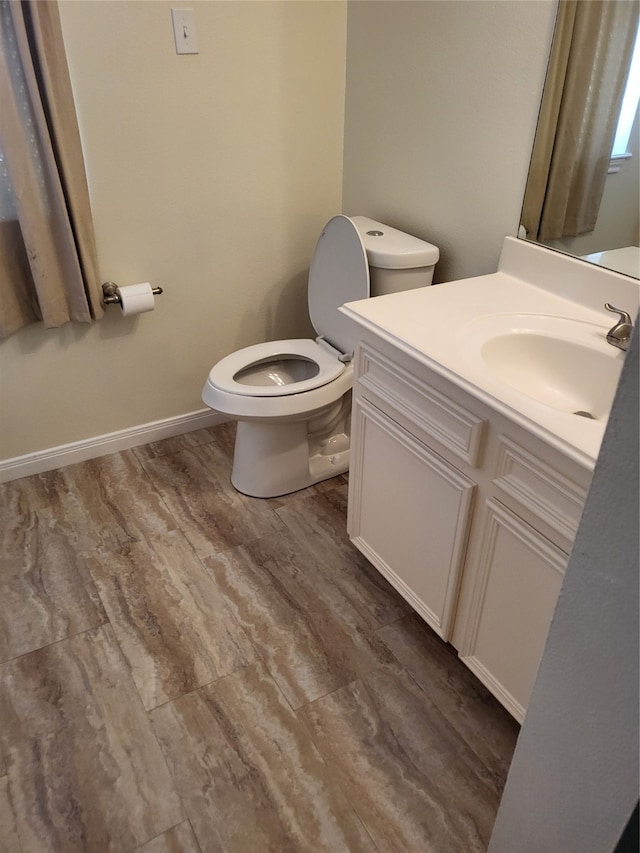 bathroom with hardwood / wood-style flooring, vanity, and toilet