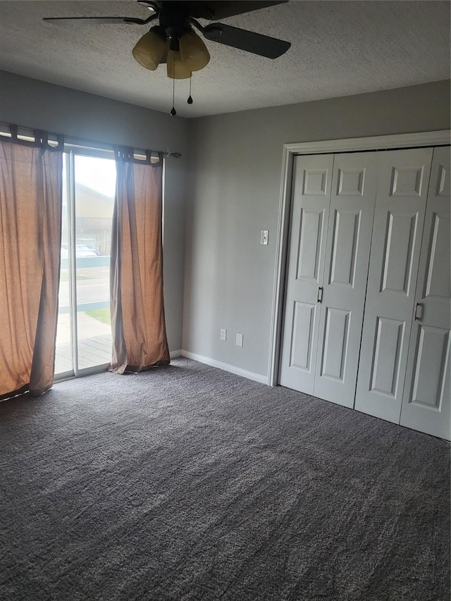 unfurnished bedroom with access to exterior, carpet, a textured ceiling, ceiling fan, and a closet