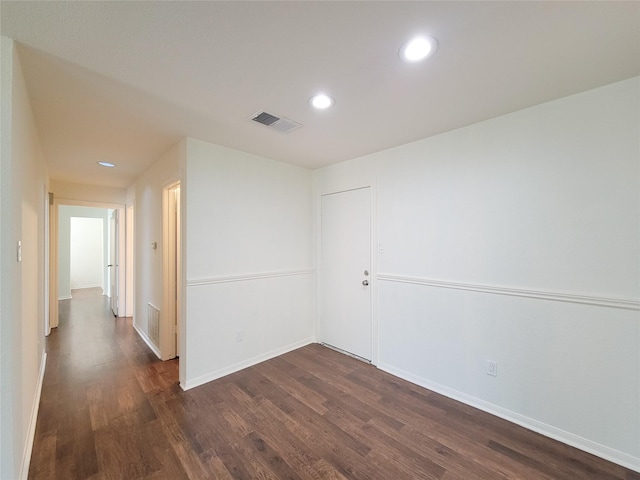 unfurnished room with dark wood-type flooring, recessed lighting, visible vents, and baseboards