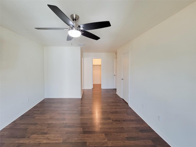 empty room featuring dark wood-style flooring, visible vents, ceiling fan, and a textured ceiling