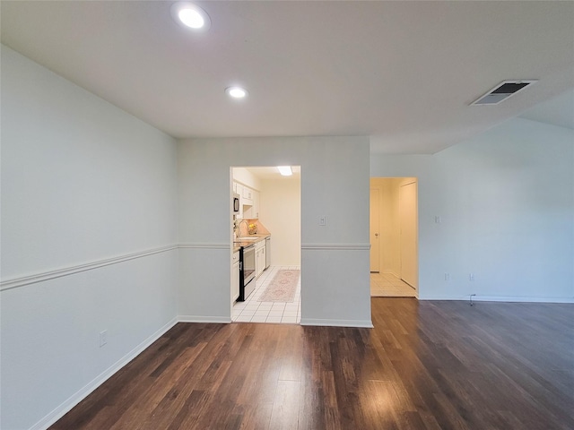 empty room featuring baseboards, light wood-style flooring, visible vents, and a sink