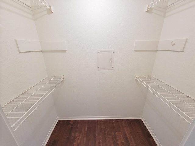 spacious closet with dark wood finished floors and electric panel