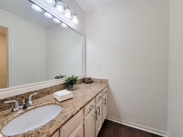 bathroom with vanity, baseboards, ornamental molding, and wood finished floors