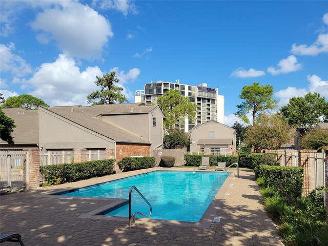 pool featuring fence and a patio