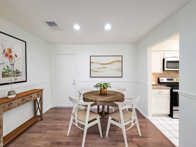 dining space with baseboards, light wood-style flooring, visible vents, and recessed lighting