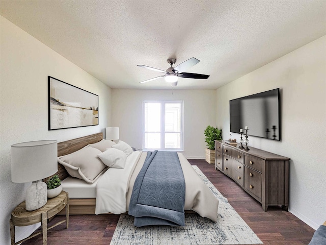 bedroom with a ceiling fan, a textured ceiling, baseboards, and dark wood-style flooring