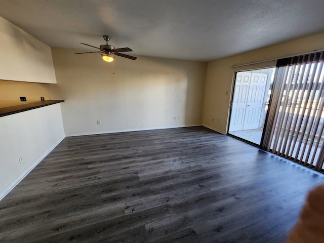 unfurnished living room featuring ceiling fan and dark hardwood / wood-style flooring