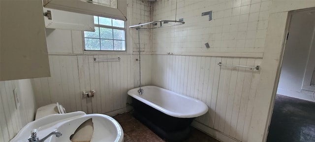 bathroom featuring toilet, wood walls, and a washtub