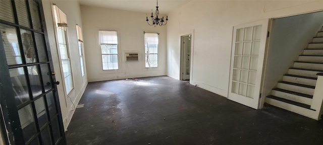 entrance foyer with french doors, an AC wall unit, and a chandelier