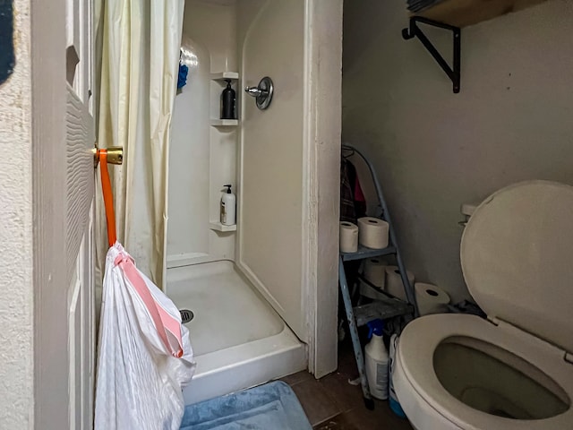 bathroom featuring toilet and curtained shower