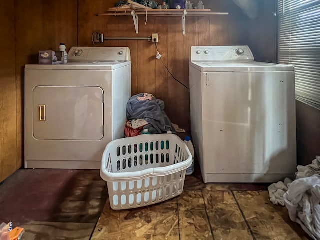 washroom featuring wood walls and separate washer and dryer