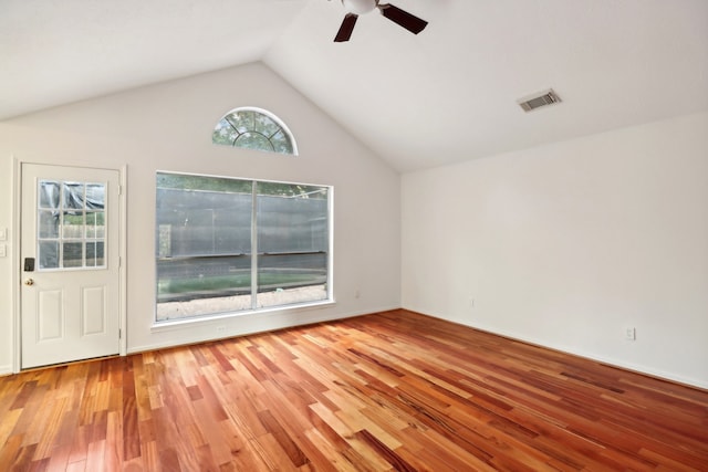 empty room with hardwood / wood-style floors, ceiling fan, and high vaulted ceiling