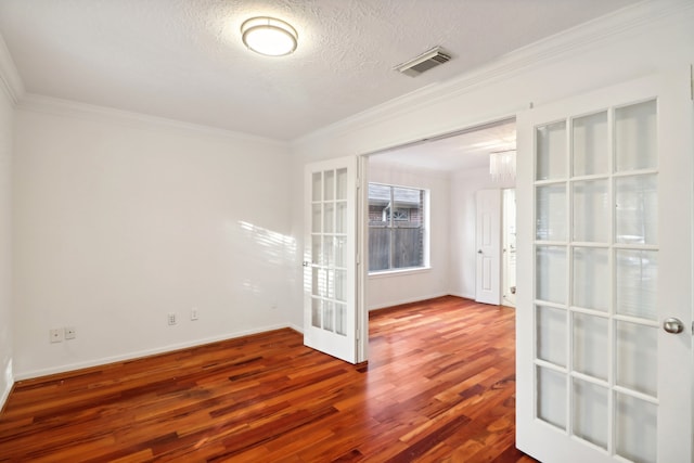 unfurnished room featuring a textured ceiling, french doors, hardwood / wood-style flooring, and crown molding