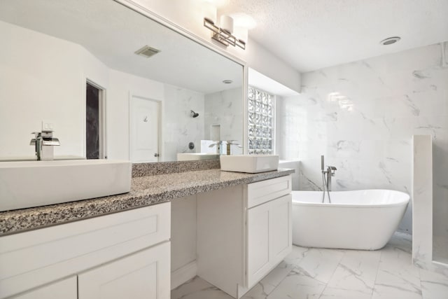 bathroom featuring vanity, shower with separate bathtub, and a textured ceiling