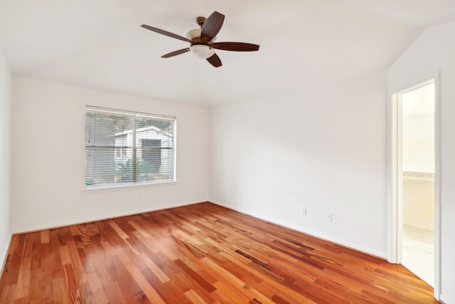 spare room featuring ceiling fan, light wood-type flooring, and lofted ceiling