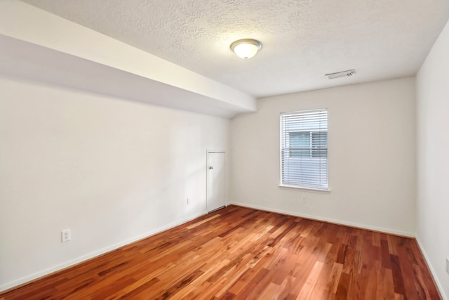 empty room featuring hardwood / wood-style floors and a textured ceiling