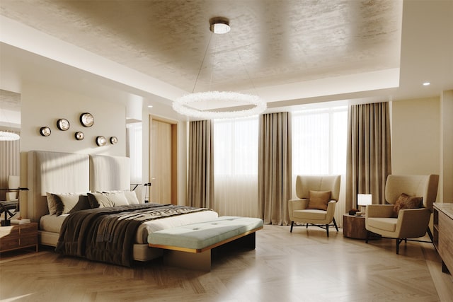 bedroom featuring light parquet floors, a tray ceiling, and an inviting chandelier