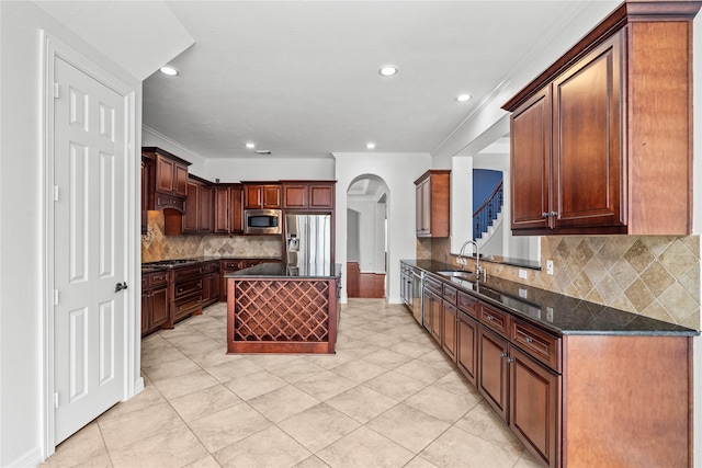 kitchen with a kitchen island, stainless steel appliances, backsplash, and dark stone countertops