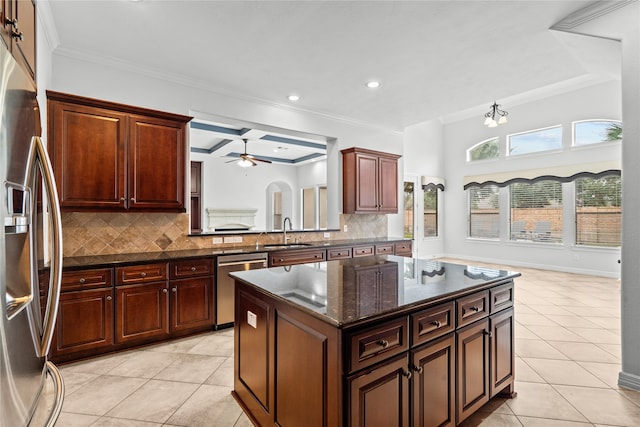 kitchen featuring sink, a center island, stainless steel appliances, decorative backsplash, and light tile patterned floors