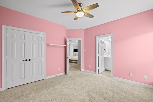 unfurnished bedroom with a closet, ceiling fan, ensuite bath, and light colored carpet