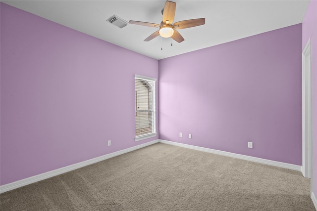 carpeted spare room with ceiling fan