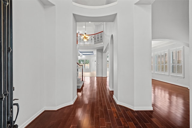 entryway with ornamental molding, a high ceiling, a chandelier, and dark hardwood / wood-style floors