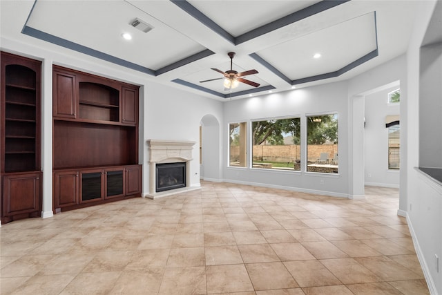 unfurnished living room with beamed ceiling, coffered ceiling, light tile patterned floors, and ceiling fan