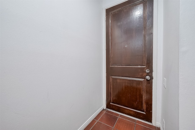 doorway featuring dark tile patterned flooring