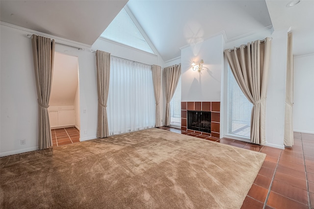 unfurnished living room with vaulted ceiling, tile patterned floors, crown molding, and a tile fireplace