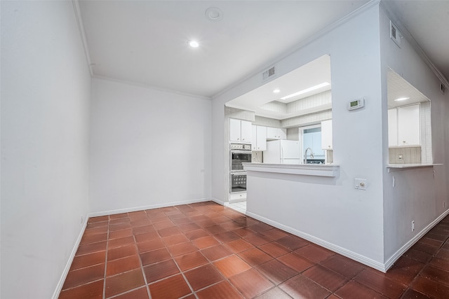 unfurnished living room with sink, dark tile patterned flooring, and ornamental molding