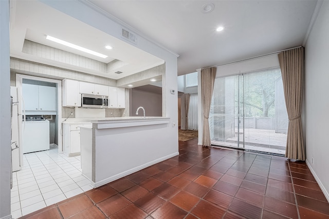 kitchen featuring washer / dryer, crown molding, sink, white cabinets, and kitchen peninsula