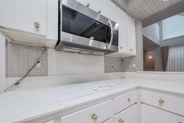 kitchen featuring white cabinets and backsplash