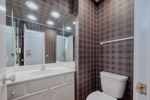 bathroom with tile walls, vanity, and toilet