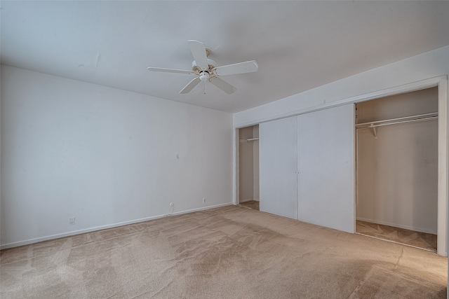 unfurnished bedroom with a closet, light colored carpet, and ceiling fan