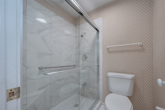 bathroom with a shower with shower door and toilet