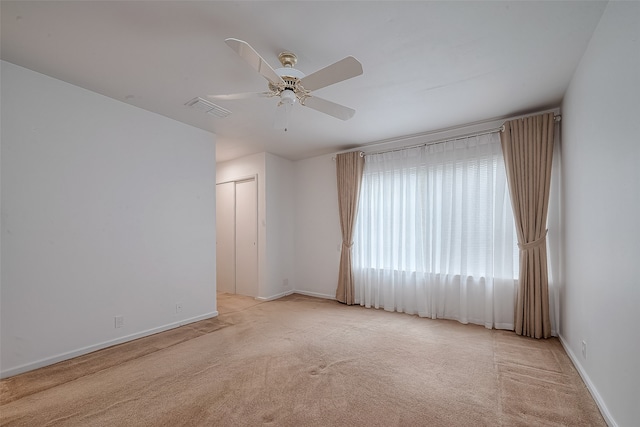 carpeted empty room featuring ceiling fan