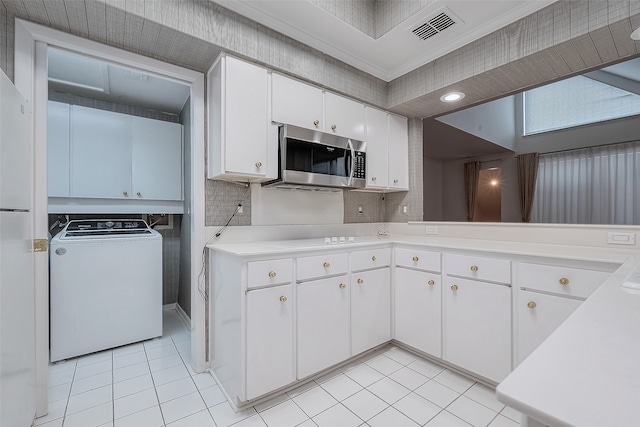 kitchen with electric cooktop, white cabinets, ornamental molding, light tile patterned flooring, and washer / clothes dryer