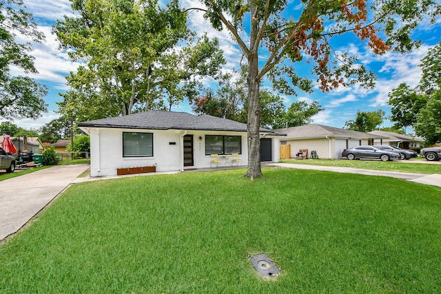 ranch-style home featuring a front lawn, covered porch, and a garage