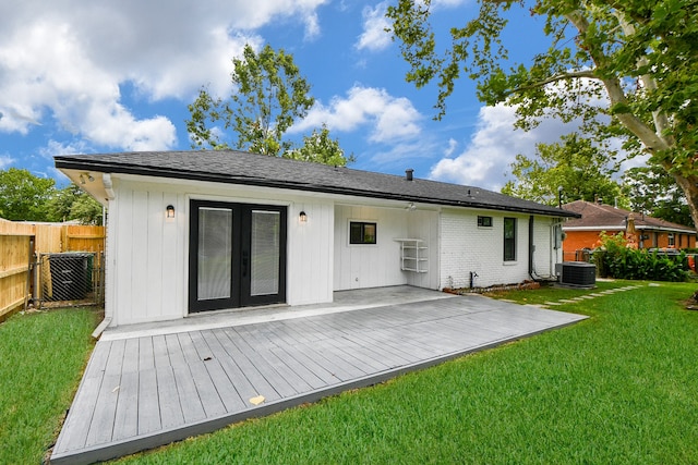 back of property with a yard, cooling unit, and french doors