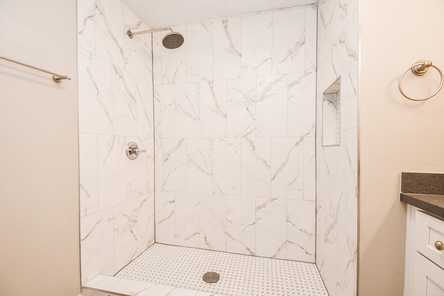 bathroom featuring vanity and tiled shower