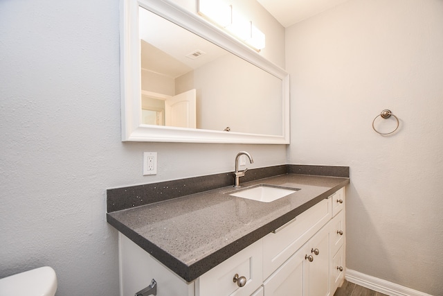 bathroom with vanity, toilet, and wood-type flooring