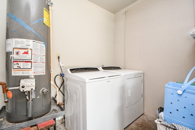 laundry room featuring water heater and washing machine and clothes dryer