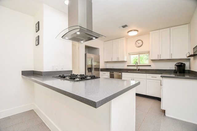 kitchen with kitchen peninsula, white cabinetry, island range hood, sink, and stainless steel appliances