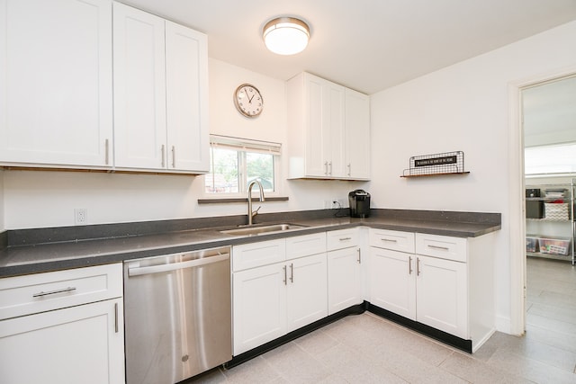 kitchen featuring stainless steel dishwasher, sink, and white cabinets